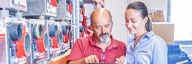 [Translate to Italiano:] Mann und Frau mit Tablet am Arbeitsplatz