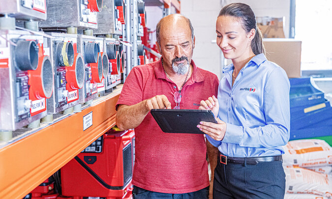 [Translate to Polski:] Mann und Frau mit Tablet am Arbeitsplatz