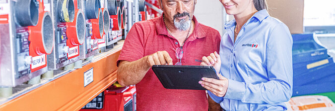 BELFOR-anställda kontrollerar data på en surfplatta bredvid torkmaskiner