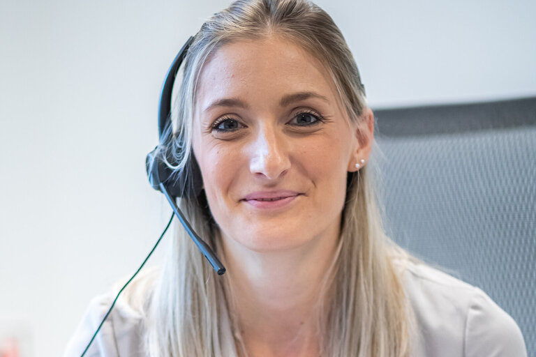 Frau mit Headset lächelt in Kamera