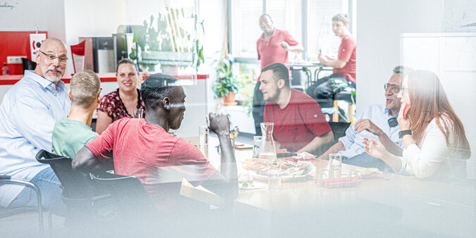 Diverse persone discutono attorno a un tavolo nella sala riunioni.