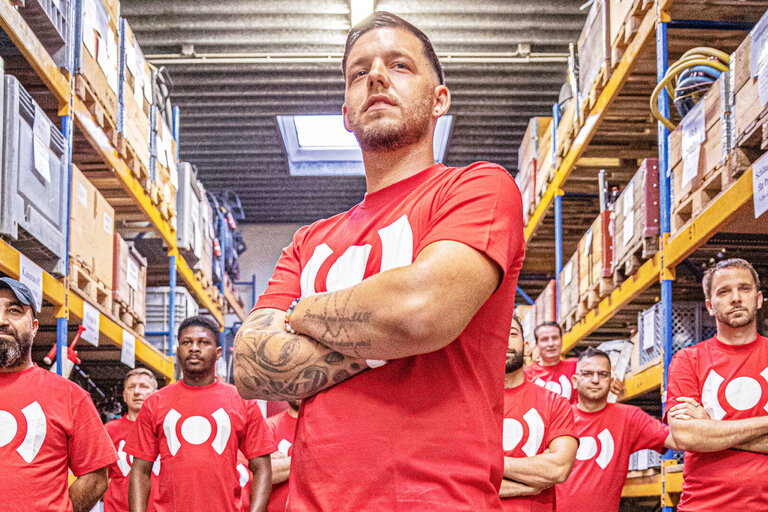 Groep BELFOR-collega's in werkkleding toont teamgeest in een hal.