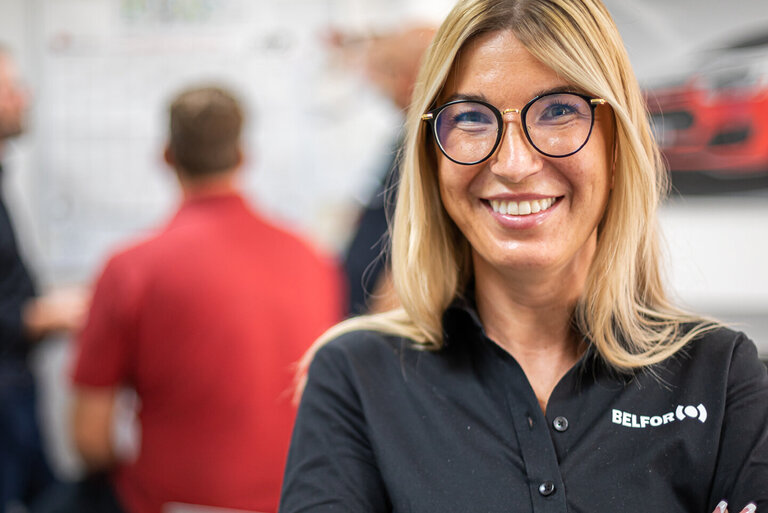 BELFOR-medarbejder på kontoret smiler til kameraet.